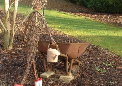 Woven willow figure with wheelbarrow at Willows Nursery. Woven willow bulrush decorations using corn dolly weave at Willows Nursery. Buy willow to make.